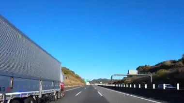 Sonbahar havasında Japonya 'da otoyolda araba sürerken pov zamanlaması. Yüksek kalite 4K görüntü. 12.04.2023 Burası Japonya 'nın Kyoto ve Aichi illerinde Shin Meishin Otoyolu..