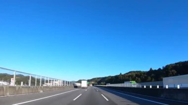 Sonbahar havasında Japonya 'da otoyolda araba sürerken pov zamanlaması. Yüksek kalite 4K görüntü. 12.04.2023 Burası Japonya 'nın Kyoto ve Aichi illerinde Shin Meishin Otoyolu..