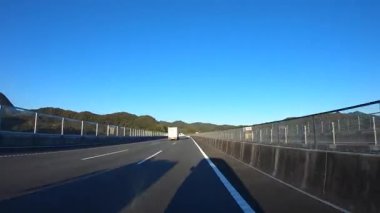 Sonbahar havasında Japonya 'da otoyolda araba sürerken pov zamanlaması. Yüksek kalite 4K görüntü. 12.04.2023 Burası Japonya 'nın Kyoto ve Aichi illerinde Shin Meishin Otoyolu..