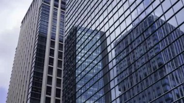 İş kasabasındaki ofis binasını yansıtan hareket eden bulutlar. Yüksek kalite 4K görüntü. Shinjuku Bölgesi Nishishinjuku Tokyo Japonya 06.27.2025 Tokyo 'nun merkezidir.. 