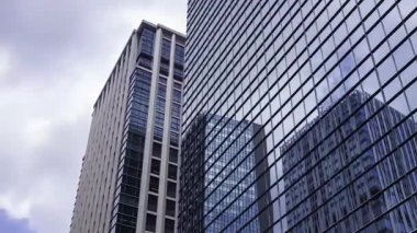 İş kasabasındaki ofis binasını yansıtan hareket eden bulutlar. Yüksek kalite 4K görüntü. Shinjuku Bölgesi Nishishinjuku Tokyo Japonya 06.27.2025 Tokyo 'nun merkezidir.. 