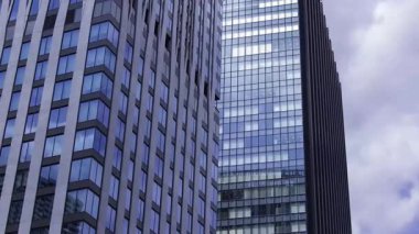 İş kasabasındaki ofis binasını yansıtan hareket eden bulutlar. Yüksek kalite 4K görüntü. Shinjuku Bölgesi Nishishinjuku Tokyo Japonya 06.27.2025 Tokyo 'nun merkezidir.. 