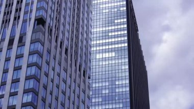 İş kasabasındaki ofis binasını yansıtan hareket eden bulutlar. Yüksek kalite 4K görüntü. Shinjuku Bölgesi Nishishinjuku Tokyo Japonya 06.27.2025 Tokyo 'nun merkezidir.. 