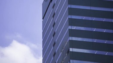 İş kasabasındaki ofis binasını yansıtan hareket eden bulutlar. Yüksek kalite 4K görüntü. Shinjuku Bölgesi Nishishinjuku Tokyo Japonya 06.27.2025 Tokyo 'nun merkezidir.. 