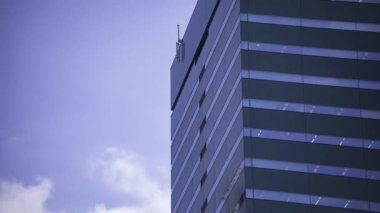 İş kasabasındaki ofis binasını yansıtan hareket eden bulutlar. Yüksek kalite 4K görüntü. Shinjuku Bölgesi Nishishinjuku Tokyo Japonya 06.27.2025 Tokyo 'nun merkezidir.. 