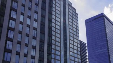 İş kasabasındaki ofis binasını yansıtan hareket eden bulutlar. Yüksek kalite 4K görüntü. Shinjuku Bölgesi Nishishinjuku Tokyo Japonya 06.27.2025 Tokyo 'nun merkezidir.. 