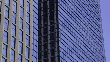 İş kasabasındaki ofis binasını yansıtan hareket eden bulutlar. Yüksek kalite 4K görüntü. Shinjuku Bölgesi Nishishinjuku Tokyo Japonya 06.27.2025 Tokyo 'nun merkezidir.. 