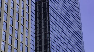 İş kasabasındaki ofis binasını yansıtan hareket eden bulutlar. Yüksek kalite 4K görüntü. Shinjuku Bölgesi Nishishinjuku Tokyo Japonya 06.27.2025 Tokyo 'nun merkezidir.. 