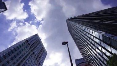 İş kasabasındaki ofis binasını yansıtan hareket eden bulutlar. Yüksek kalite 4K görüntü. Shinjuku Bölgesi Nishishinjuku Tokyo Japonya 06.27.2025 Tokyo 'nun merkezidir.. 