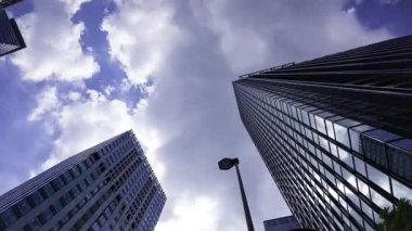 İş kasabasındaki ofis binasını yansıtan hareket eden bulutlar. Yüksek kalite 4K görüntü. Shinjuku Bölgesi Nishishinjuku Tokyo Japonya 06.27.2025 Tokyo 'nun merkezidir.. 