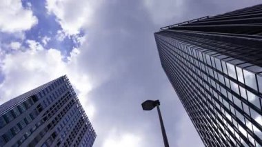 İş kasabasındaki ofis binasını yansıtan hareket eden bulutlar. Yüksek kalite 4K görüntü. Shinjuku Bölgesi Nishishinjuku Tokyo Japonya 06.27.2025 Tokyo 'nun merkezidir.. 