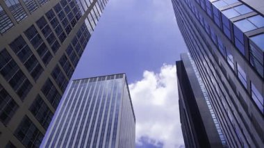 İş kasabasındaki ofis binasını yansıtan hareket eden bulutlar. Yüksek kalite 4K görüntü. Shinjuku Bölgesi Nishishinjuku Tokyo Japonya 06.27.2025 Tokyo 'nun merkezidir.. 