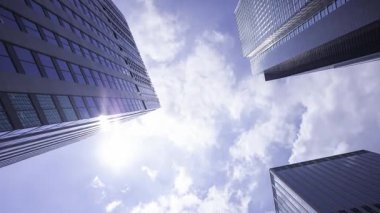 İş kasabasındaki ofis binasını yansıtan hareket eden bulutlar. Yüksek kalite 4K görüntü. Shinjuku Bölgesi Nishishinjuku Tokyo Japonya 06.27.2025 Tokyo 'nun merkezidir.. 