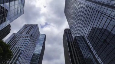 İş kasabasındaki ofis binasını yansıtan hareket eden bulutlar. Yüksek kalite 4K görüntü. Shinjuku Bölgesi Nishishinjuku Tokyo Japonya 06.27.2025 Tokyo 'nun merkezidir.. 