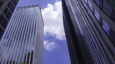 İş kasabasındaki ofis binasını yansıtan hareket eden bulutlar. Yüksek kalite 4K görüntü. Shinjuku Bölgesi Nishishinjuku Tokyo Japonya 06.27.2025 Tokyo 'nun merkezidir.. 