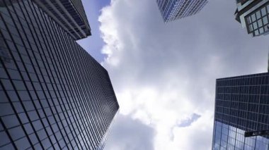 İş kasabasındaki ofis binasını yansıtan hareket eden bulutlar. Yüksek kalite 4K görüntü. Shinjuku Bölgesi Nishishinjuku Tokyo Japonya 06.27.2025 Tokyo 'nun merkezidir.. 