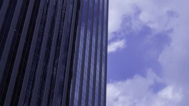 İş kasabasındaki ofis binasını yansıtan hareket eden bulutlar. Yüksek kalite 4K görüntü. Shinjuku Bölgesi Nishishinjuku Tokyo Japonya 06.27.2025 Tokyo 'nun merkezidir.. 