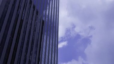 İş kasabasındaki ofis binasını yansıtan hareket eden bulutlar. Yüksek kalite 4K görüntü. Shinjuku Bölgesi Nishishinjuku Tokyo Japonya 06.27.2025 Tokyo 'nun merkezidir.. 