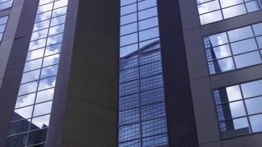 İş kasabasındaki ofis binasını yansıtan hareket eden bulutlar. Yüksek kalite 4K görüntü. Shinjuku Bölgesi Nishishinjuku Tokyo Japonya 06.27.2025 Tokyo 'nun merkezidir.. 