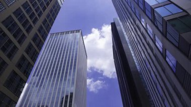 İş kasabasındaki ofis binasını yansıtan hareket eden bulutlar. Yüksek kalite 4K görüntü. Shinjuku Bölgesi Nishishinjuku Tokyo Japonya 06.27.2025 Tokyo 'nun merkezidir.. 