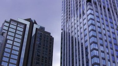 İş kasabasındaki ofis binasını yansıtan hareket eden bulutlar. Yüksek kalite 4K görüntü. Shinjuku Bölgesi Nishishinjuku Tokyo Japonya 06.27.2025 Tokyo 'nun merkezidir.. 