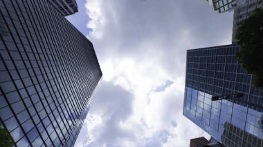 İş kasabasındaki ofis binasını yansıtan hareket eden bulutlar. Yüksek kalite 4K görüntü. Shinjuku Bölgesi Nishishinjuku Tokyo Japonya 06.27.2025 Tokyo 'nun merkezidir.. 