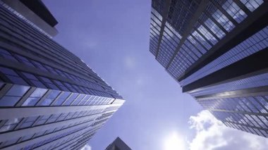 İş kasabasındaki ofis binasını yansıtan hareket eden bulutlar. Yüksek kalite 4K görüntü. Shinjuku Bölgesi Nishishinjuku Tokyo Japonya 06.27.2025 Tokyo 'nun merkezidir.. 