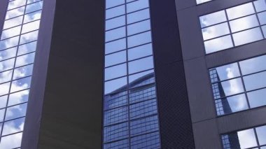 İş kasabasındaki ofis binasını yansıtan hareket eden bulutlar. Yüksek kalite 4K görüntü. Shinjuku Bölgesi Nishishinjuku Tokyo Japonya 06.27.2025 Tokyo 'nun merkezidir.. 