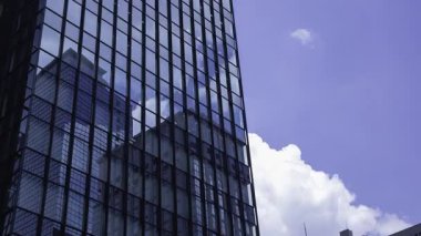 İş kasabasındaki ofis binasını yansıtan hareket eden bulutlar. Yüksek kalite 4K görüntü. Shinjuku Bölgesi Nishishinjuku Tokyo Japonya 06.27.2025 Tokyo 'nun merkezidir.. 