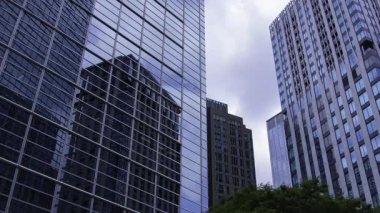 İş kasabasındaki ofis binasını yansıtan hareket eden bulutlar. Yüksek kalite 4K görüntü. Shinjuku Bölgesi Nishishinjuku Tokyo Japonya 06.27.2025 Tokyo 'nun merkezidir.. 