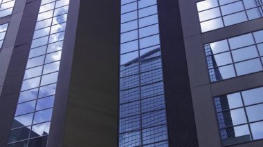 İş kasabasındaki ofis binasını yansıtan hareket eden bulutlar. Yüksek kalite 4K görüntü. Shinjuku Bölgesi Nishishinjuku Tokyo Japonya 06.27.2025 Tokyo 'nun merkezidir.. 