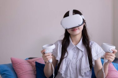 Odada VR camlarıyla oynayan bir Japon kadın. Yüksek kalite fotoğraf 06.12.2025