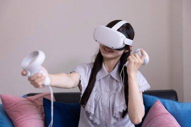 Odada VR camlarıyla oynayan bir Japon kadın. Yüksek kalite fotoğraf 06.12.2025