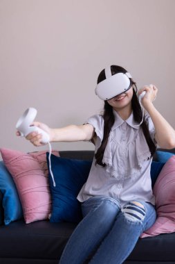 Odada VR camlarıyla oynayan bir Japon kadın. Yüksek kalite fotoğraf 06.12.2025