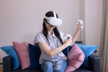 Odada VR camlarıyla oynayan bir Japon kadın. Yüksek kalite fotoğraf 06.12.2025