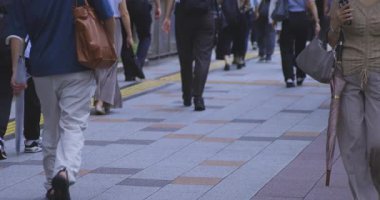 Tokyo 'daki şehir sokaklarında yürüyen insanların yavaş çekimleri. Yüksek kalite 4K görüntü. Kouto bölgesi Kachidoki Tokyo 07.16.2025 Tokyo 'nun merkezidir.. 