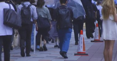 Tokyo 'daki şehir sokaklarında yürüyen insanların yavaş çekimleri. Yüksek kalite 4K görüntü. Kouto bölgesi Kachidoki Tokyo 07.16.2025 Tokyo 'nun merkezidir.. 