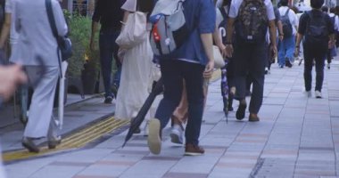 Tokyo 'daki şehir sokaklarında yürüyen insanların yavaş çekimleri. Yüksek kalite 4K görüntü. Kouto bölgesi Kachidoki Tokyo 07.16.2025 Tokyo 'nun merkezidir.. 