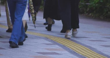 Tokyo 'daki şehir sokaklarında yürüyen insanların yavaş çekimleri. Yüksek kalite 4K görüntü. Kouto bölgesi Kachidoki Tokyo 07.16.2025 Tokyo 'nun merkezidir.. 