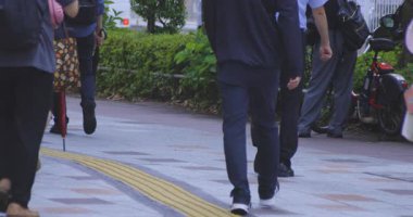 Tokyo 'daki şehir sokaklarında yürüyen insanların yavaş çekimleri. Yüksek kalite 4K görüntü. Kouto bölgesi Kachidoki Tokyo 07.16.2025 Tokyo 'nun merkezidir.. 