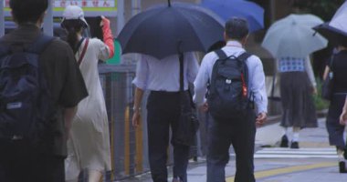 Yağmurlu bir günde Tokyo caddesinde yürüyen banliyö sakinleri. Yüksek kalite 4K görüntü. Kouto bölgesi Kachidoki Tokyo 07.16.2025 Tokyo 'nun merkezidir.. 