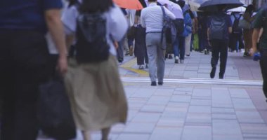 Yağmurlu bir günde Tokyo caddesinde yürüyen banliyö sakinleri. Yüksek kalite 4K görüntü. Kouto bölgesi Kachidoki Tokyo 07.16.2025 Tokyo 'nun merkezidir.. 