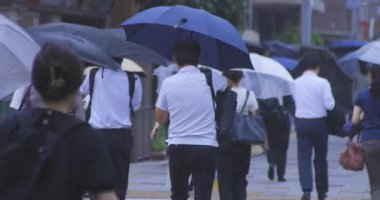 Yağmurlu bir günde Tokyo caddesinde yürüyen banliyö sakinleri. Yüksek kalite 4K görüntü. Kouto bölgesi Kachidoki Tokyo 07.16.2025 Tokyo 'nun merkezidir.. 