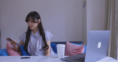 Oturma odasında elinde Card ve Smartphone olan bir Japon kadın. Yüksek kalite 4K görüntü. Tokyo Japonya 06.19.2025