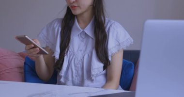 Oturma odasında elinde Card ve Smartphone olan bir Japon kadın. Yüksek kalite 4K görüntü. Tokyo Japonya 06.19.2025