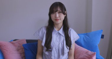 Oturma odasında elinde Card ve Smartphone olan bir Japon kadın. Yüksek kalite 4K görüntü. Tokyo Japonya 06.19.2025