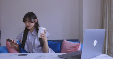 Japon bir kadın oturma odasında akıllı telefondan alışveriş yapıyor. Yüksek kalite 4K görüntü. Tokyo Japonya 06.12.2025