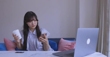 Japon bir kadın oturma odasında akıllı telefondan alışveriş yapıyor. Yüksek kalite 4K görüntü. Tokyo Japonya 06.12.2025