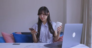 Japon bir kadın oturma odasında akıllı telefondan alışveriş yapıyor. Yüksek kalite 4K görüntü. Tokyo Japonya 06.12.2025