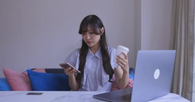 Japon bir kadın oturma odasında akıllı telefondan alışveriş yapıyor. Yüksek kalite 4K görüntü. Tokyo Japonya 06.12.2025